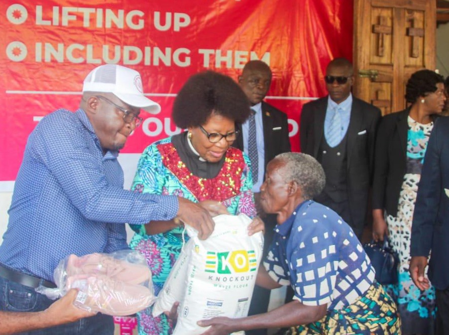 Dr. Jane Ansah Foundation team distributing maize flour and supplies to an elderly beneficiary